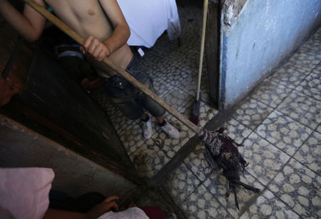 © Reuters. A child cleans his room at a home known as "La Gran Familia", in the western city of Zamora