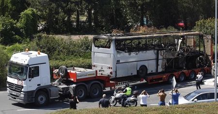 © Reuters. A truck carries a bus, that was damaged in a bomb blast on Wednesday, outside Burgas Airport