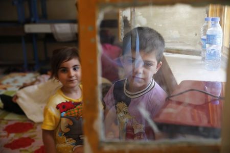 © Reuters. Children of a Christian family, who fled from the violence in Mosul two days ago, stay at a school in Arbil, in Iraq's Kurdistan region