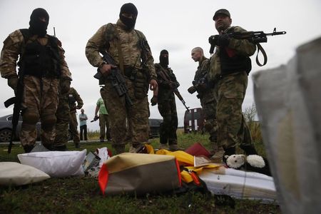 © Reuters. Separatistas pró-russos observam pertences de passageiros de avião derrubado na Ucrânia