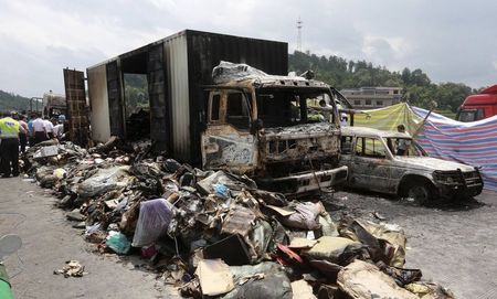 © Reuters. Debris is seen next to burnt vehicles after an explosion and a fire following a traffic accident, at a section of the Hukun highway in Shaoyang