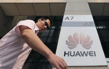 © Reuters. A man walks past a Huawei company logo outside the entrance of a Huawei office in Wuhan, Hubei province