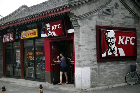 © Reuters. A woman holding an ice cream walks out of a KFC restaurant in Beijing