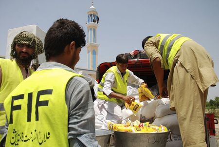 © Reuters. Volunteers arrange food packs for people fleeing military offensive in North Waziristan, in Nurar village