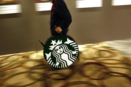 © Reuters. A man carries a Starbucks logo sign after a corporate event at a hotel in Shanghai