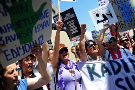 © Reuters. Women wave posters as they march in protest against domestic abuse, in Istanbul