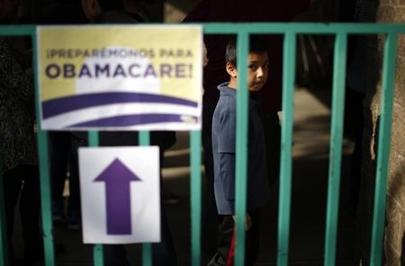 © Reuters. A boy waits in line at a health insurance enrollment event in Cudahy, California