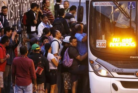 © Reuters. Pessoas embarcam em ônibus lotado na avenida Brasil, Rio de Janeiro 