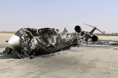 © Reuters. A wreckage of a burnt aircraft is pictured after a shelling at Tripoli International Airport
