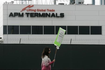 © Reuters. A union member walks a picket line near APM Terminals in Los Angeles