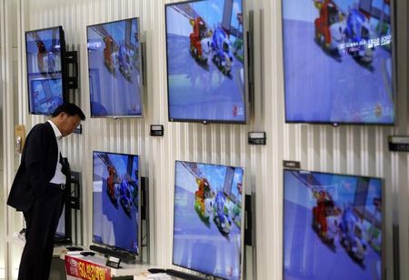 © Reuters. A customer looks at LG Electronics' TV sets which are made with LG Display flat screens at its store in Seoul