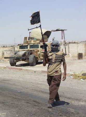 © Reuters. Боец Исламского государства Ирака и Леванта на КПП в Байджи  