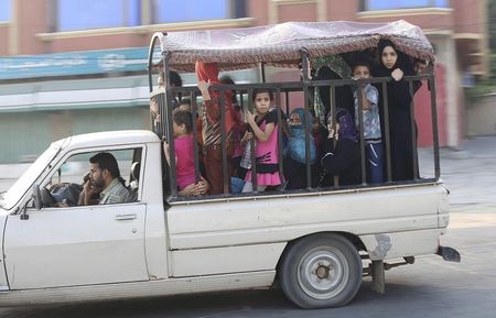 © Reuters. Palestinians ride in a vehicle as they flee their houses following heavy Israeli shelling during an Israeli ground offensive east of Khan Younis in the southern Gaza Strip