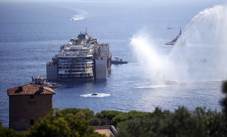 © Reuters. Tugboats spays water in farewell to the cruise liner Costa Concordia during the refloat operation maneuvers at Giglio Island