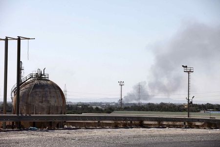 © Reuters. حريق هائل بخزانات وقود نتيجة اشتباكات قرب مطار طرابلس في ليبيا