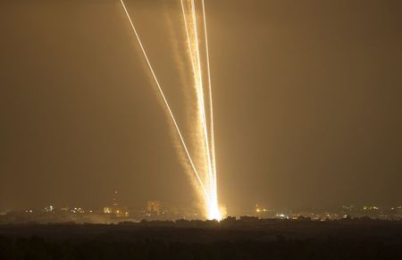 © Reuters. Light streaks and smoke trails are seen as rockets are launched from Gaza towards Israel