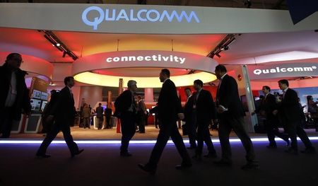 © Reuters. Visitors walk past the Qualcomm stand at the Mobile World Congress in Barcelona
