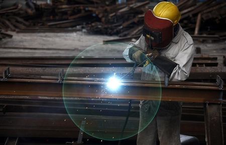 © Reuters. Worker welds at a machinery manufacturing factory in Huaibei