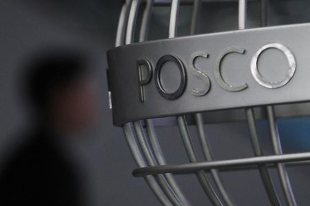 © Reuters. A man walks past a POSCO logo at the company's headquarters in Seoul