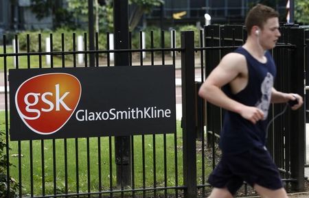 © Reuters. A jogger runs past a signage for pharmaceutical giant GlaxoSmithKline in London