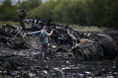 © Reuters. A journalist takes photographs at the site of Thursday's Malaysia Airlines Boeing 777 plane crash near the settlement of Grabovo, in the Donetsk region