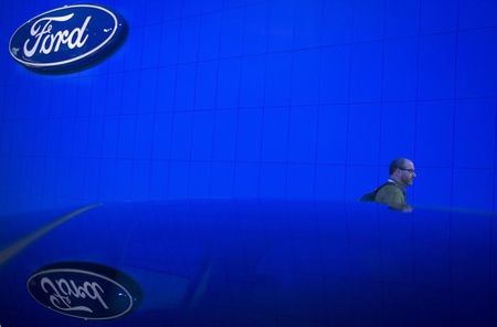 © Reuters. A man walks past new Ford car at Jacob Javits Convention Center during New York International Auto Show in New York