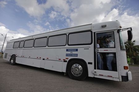 © Reuters. Bus carrying deportees from the U.S. leaves the international airport in San Pedro Sula