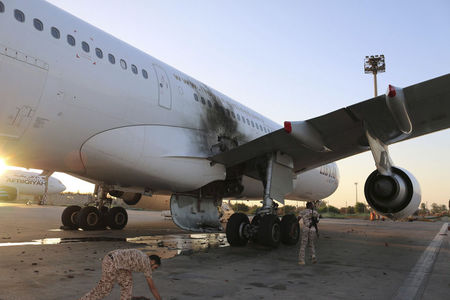 © Reuters. A damaged aircraft is pictured after a shelling at Tripoli International Airport