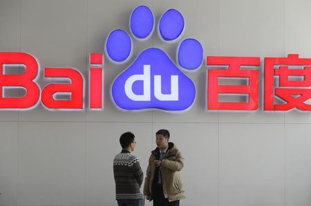 © Reuters. People talk in front of a Baidu's company logo at Baidu's headquarters in Beijing