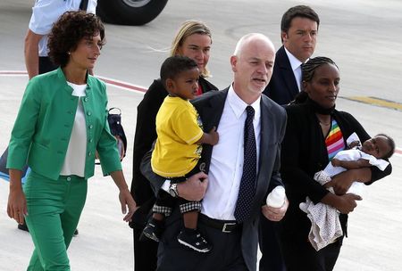 © Reuters. Mariam Yahya Ibrahim of Sudan carries one of children, as she arrives at Ciampino airport in Rome