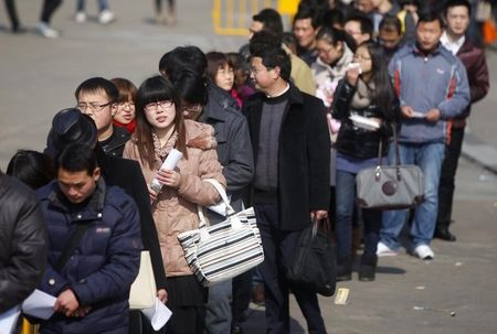 © Reuters. Job seekers wait in line during a job fair at Shanghai Stadium