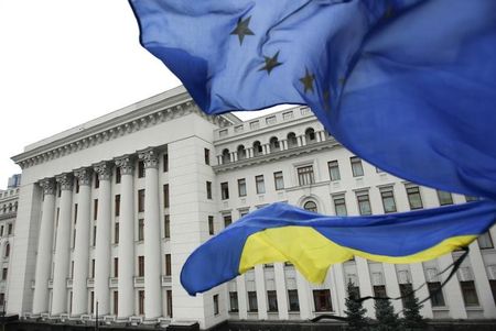 © Reuters. Ukrainian national and EU flags fly outside the presidential administration building in Kiev