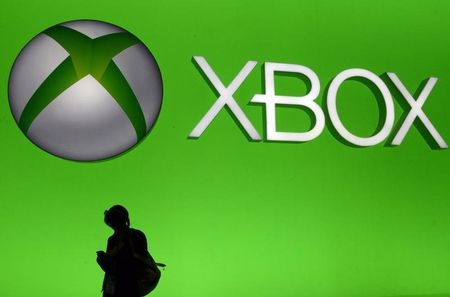 © Reuters. An attendee uses her smartphone in front of a giant Microsoft Xbox sign at the 2014 Electronic Entertainment Expo, known as E3, in Los Angeles