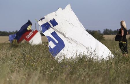 © Reuters. A woman takes a photograph of wreckage at the crash site of Malaysia Airlines Flight MH17 near the village of Hrabove (Grabovo)