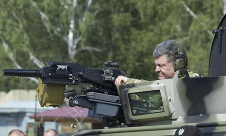 © Reuters. Presidente ucraniano, Petro Poroshenko, manuseia uma arma montada em um veículo blindado durante demonstração de novas armas das Forças Armadas da Ucrânia, em uma base militar nos arredores de Kiev