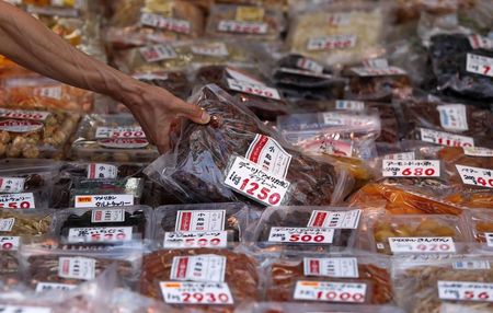 © Reuters. A shopper picks up a pack of dried dates at a food store in Tokyo