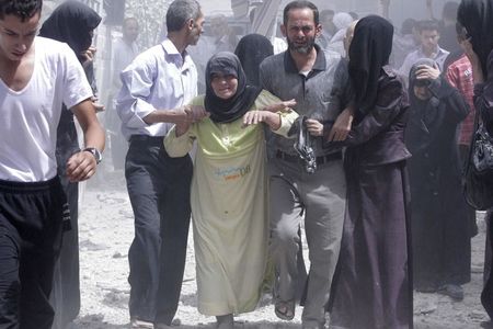 © Reuters. People assist an old woman at a site hit by what activists said was an airstrike by forces loyal to Syria's President Bashar al-Assad in Duma in eastern al-Ghouta, near Damascus