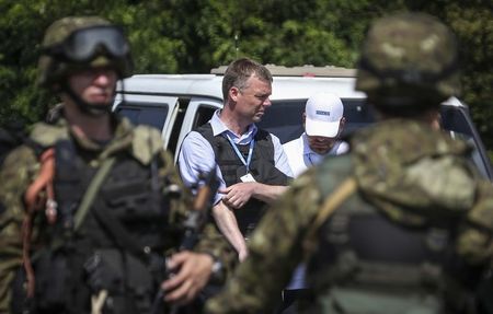 © Reuters. Equipe da Organização para Segurança e Cooperação na Europa (OSCE) fotografados ao lado de separatistas pró-Rússia enquanto se encaminham para o local da queda de um avião de passageiros malaio, no leste da Ucrânia 