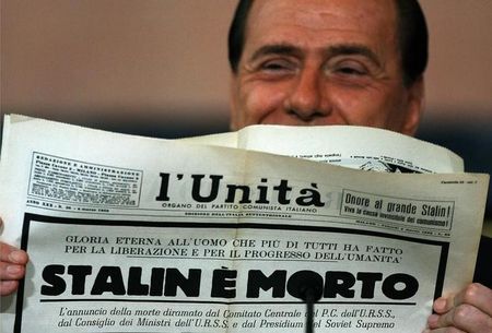 © Reuters. Italian Prime Minister Berlusconi holds up vintage newspaper in Rome