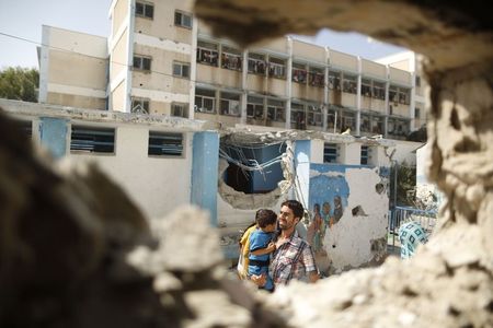 © Reuters. Homem passa por escola da ONU em Gaza que, segundo testemunhas, foi alvo de ataque de Israel