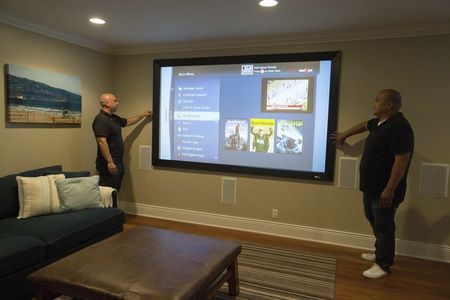 © Reuters. Vybourg and Luzadas look at a projector screen they installed in a home in Manhattan Beach