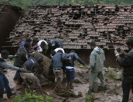 © Reuters. Rescue workers and volunteers clear the debris from the site of a landslide at Malin village in the western Indian state of Maharashtra