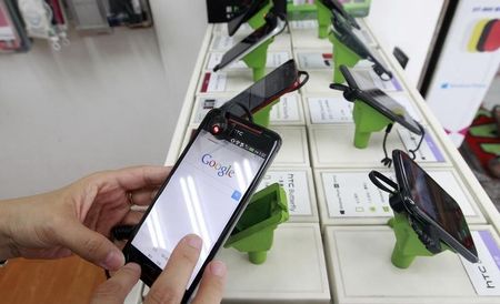 © Reuters. A customer tries out a HTC smartphone Butterfly S inside a mobile phone shop in Taipei