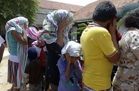 © Reuters. Sri Lankan asylum seekers who were sent back by Australia wait to enter a magistrate's court in Galle