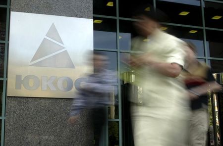 © Reuters. File photo of people walking by the Yukos oil company headquarters in Moscow