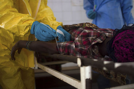 © Reuters. Equipes médicas extraem amostra de sangue de um paciente suspeito de estar infectado com o vírus Ebola, no hospital estatal em Kenema, Serra Leoa  