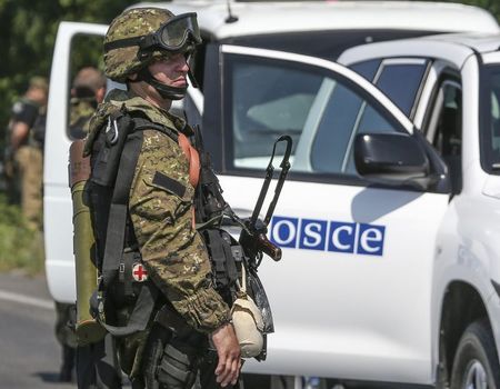 © Reuters. Separatista pró-Rússia fotografado ao lado de um veículo da Organização para Segurança e Cooperação na Europa (OSCE), no leste da Ucrânia