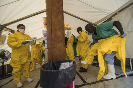 © Reuters. Médicos se equipam com equipamentos de proteção antes de entrar em centro de tratamento do vírus Ebola em Kailahun, em Serra Leoa. Nesta quinta-feira, o país decretou estado de emergência pública e convocará o exército para impor quarentena nos epicentros do vírus Ebola. 20/07/2014 REUTERS/Tommy Trenchard 