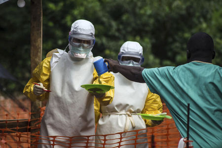 © Reuters. Funcionários da área médica que atuam com os Médicos Sem Fronteiras se preparam para levar comida a pacientes mantidos em quarentena em Serra Leoa