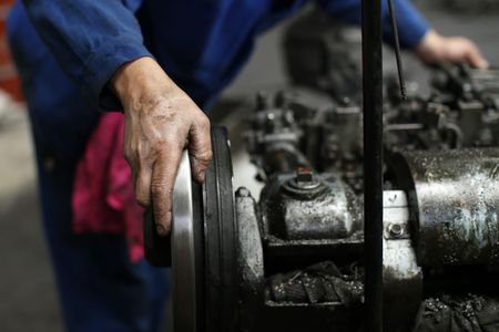 © Reuters. An employee works on a machine in the engine room at the Rivierre plant, the last remaining nails factory in operation in France, in Creil